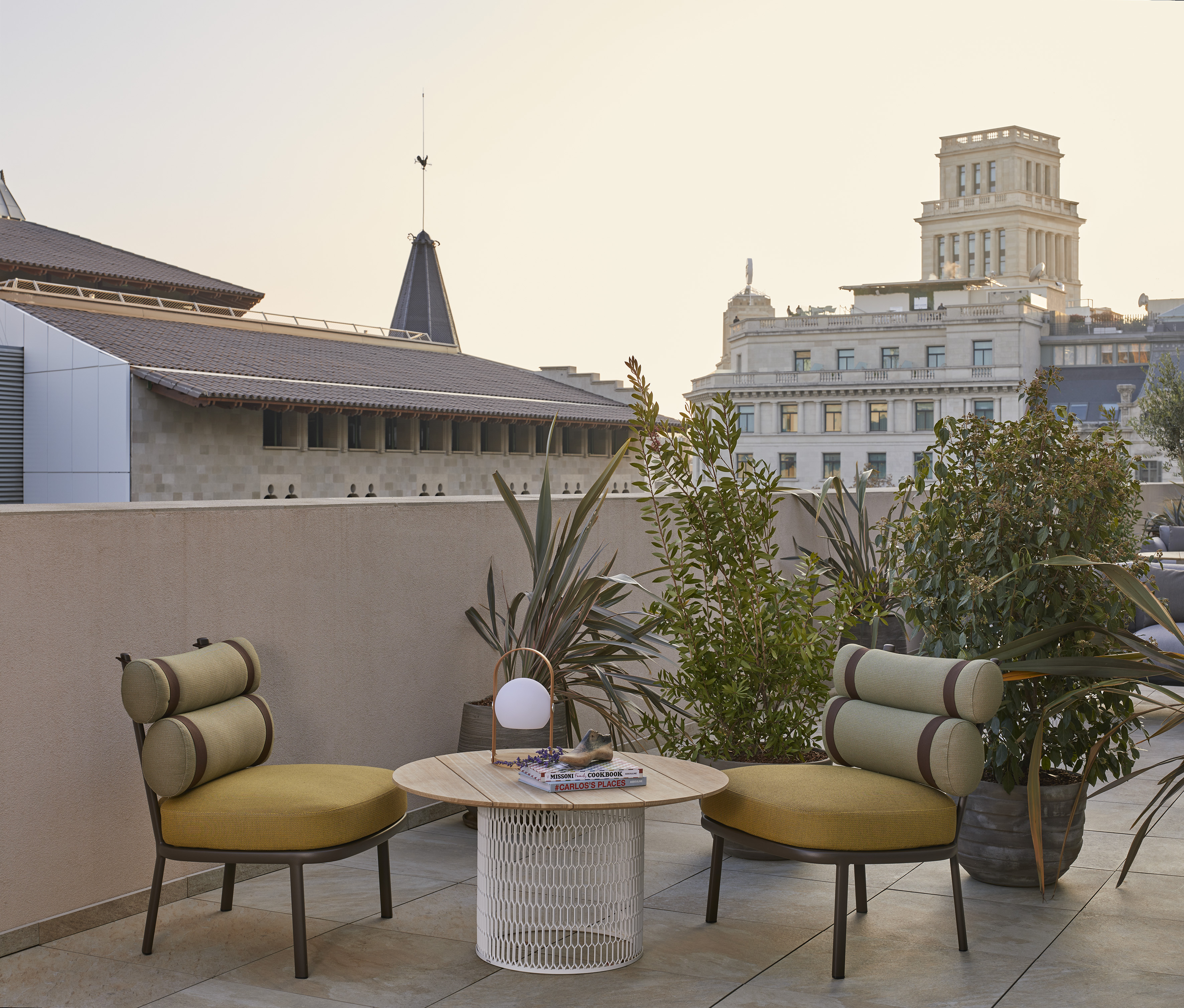 Modern rooftop terrace with yellow chairs, round table, plants, city skyline.