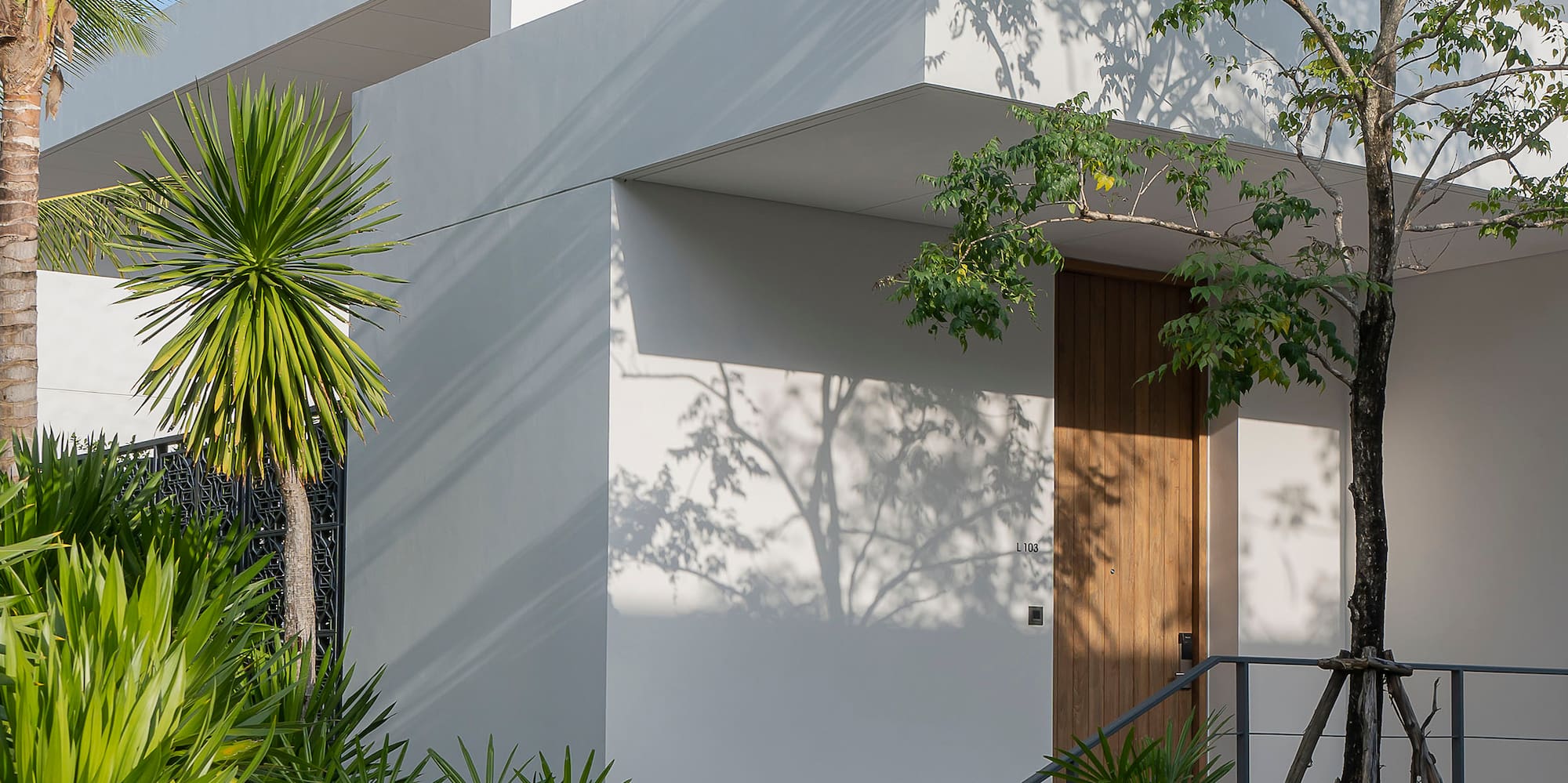 a white building with trees and plants around it