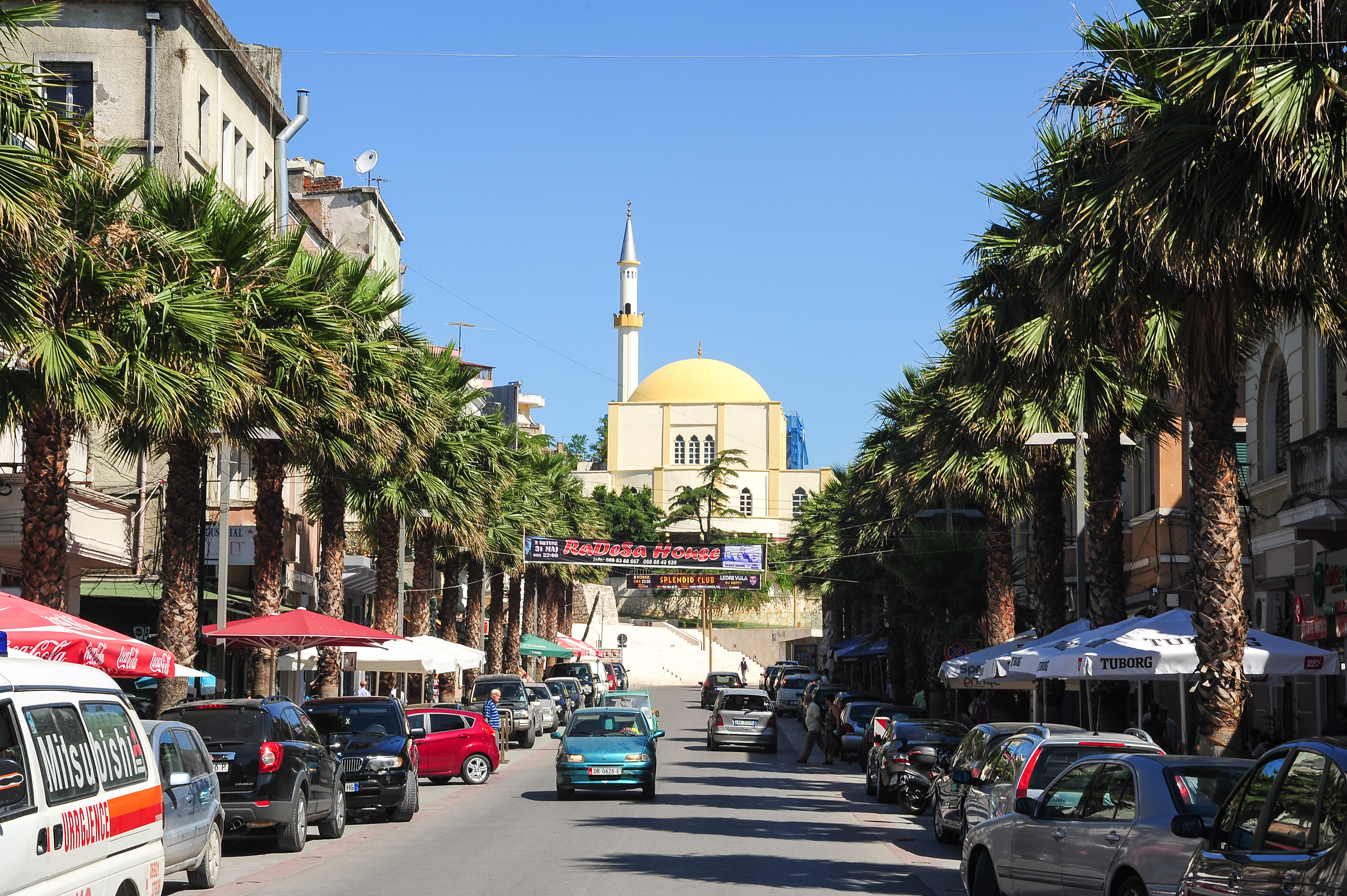 a street with cars and palm trees