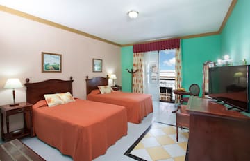 a room with two beds and a desk