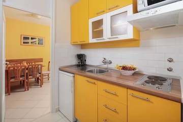 a kitchen with yellow cabinets and a white tile floor
