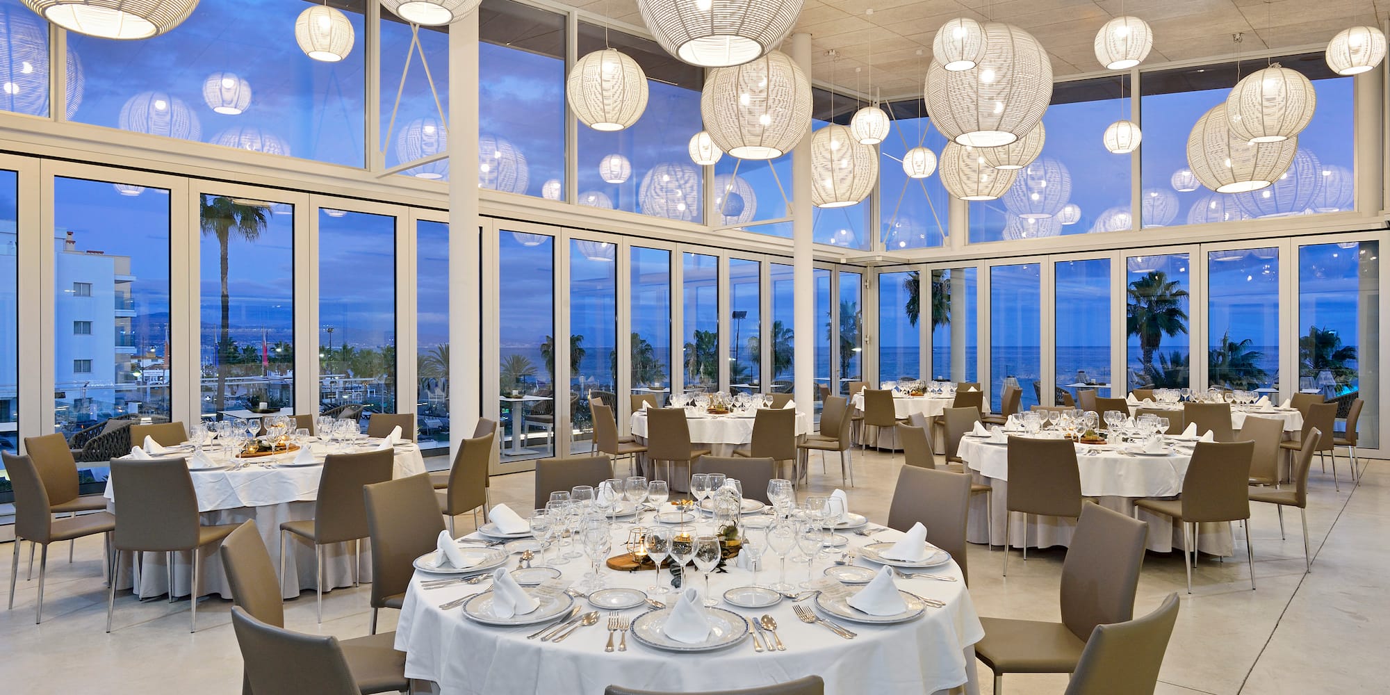 a room with tables and chairs and a large chandelier