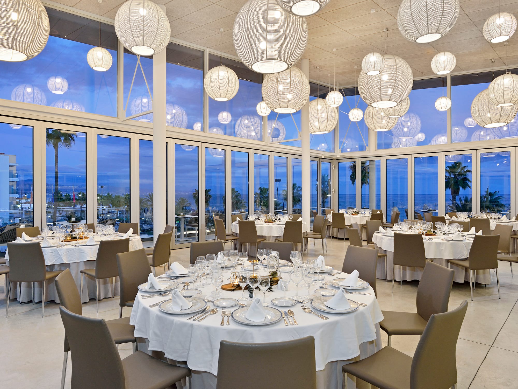 a room with tables and chairs and a large chandelier