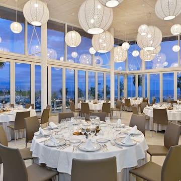 a room with tables and chairs and a large chandelier