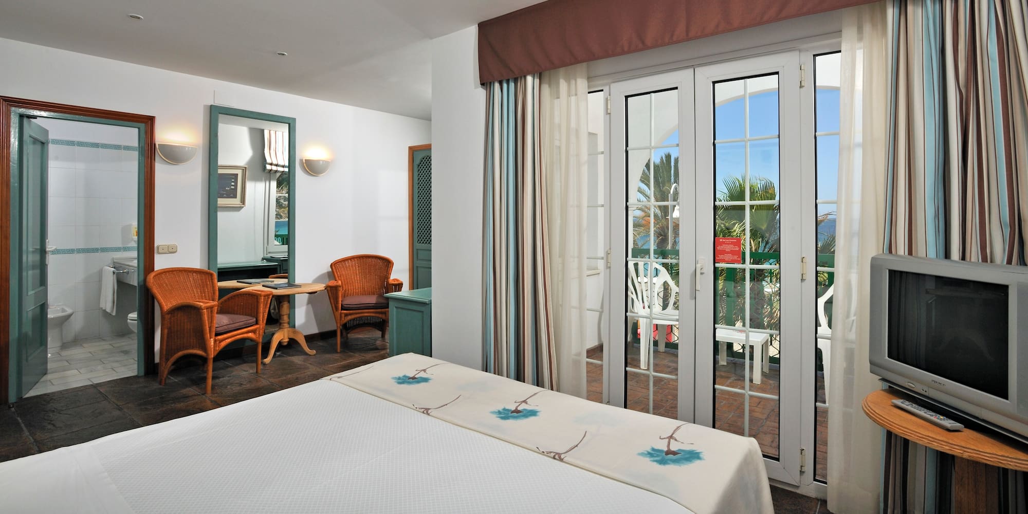 a room with a bed and glass doors