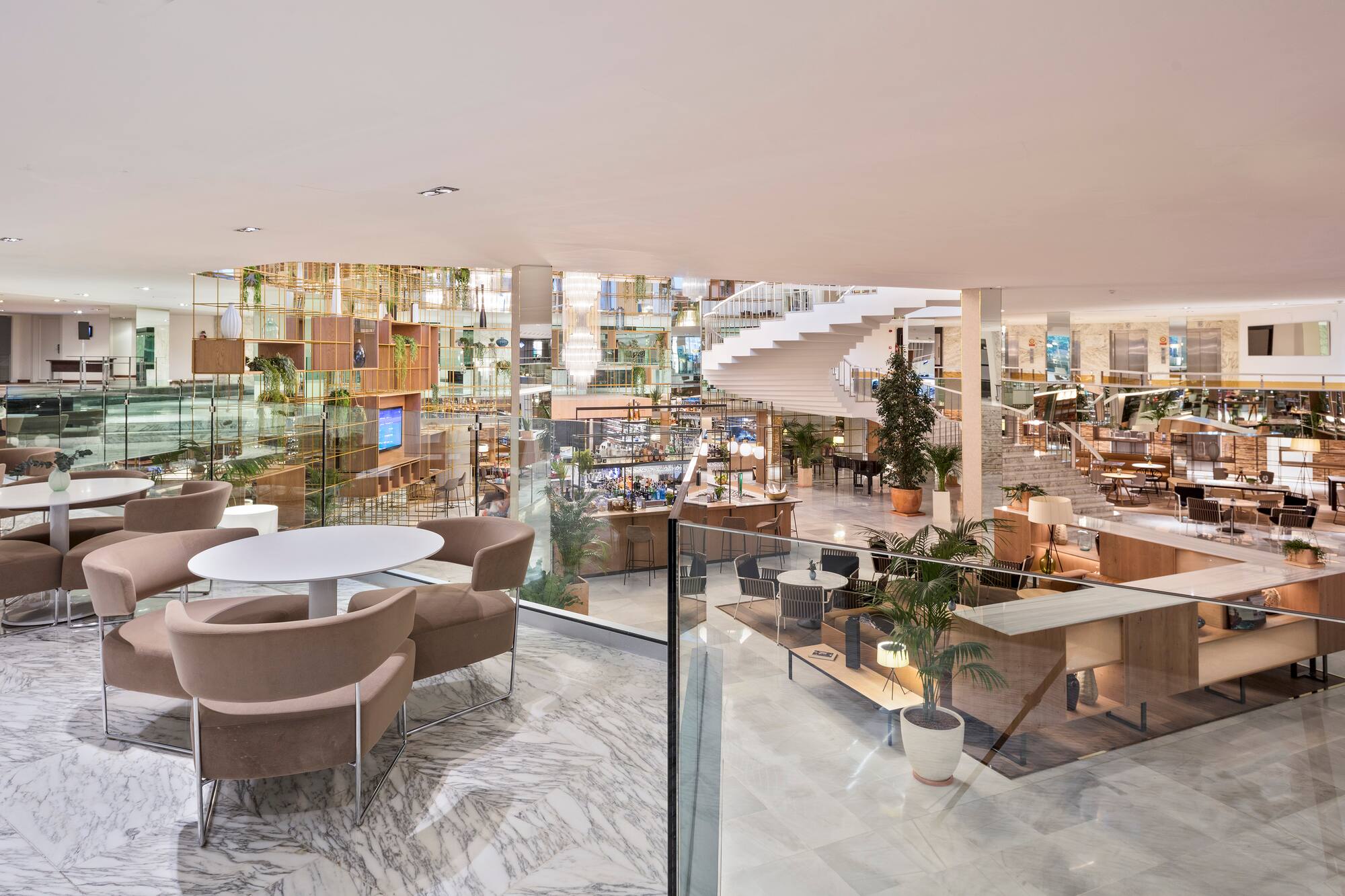 Modern hotel lobby lounge, marble floors, spiral staircase, and seating areas.