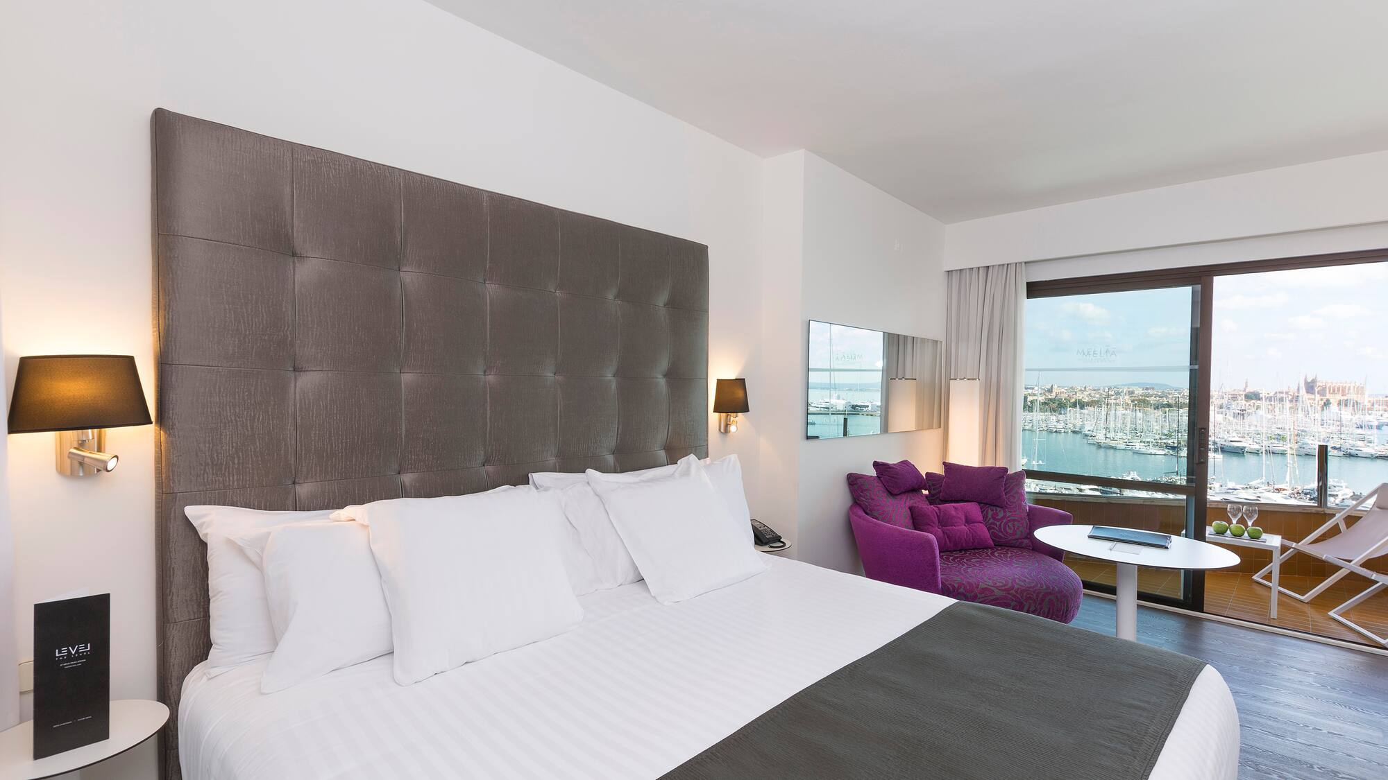 a large bed with a purple chair and a purple chair