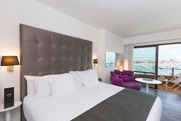 a large bed with a purple chair and a purple chair