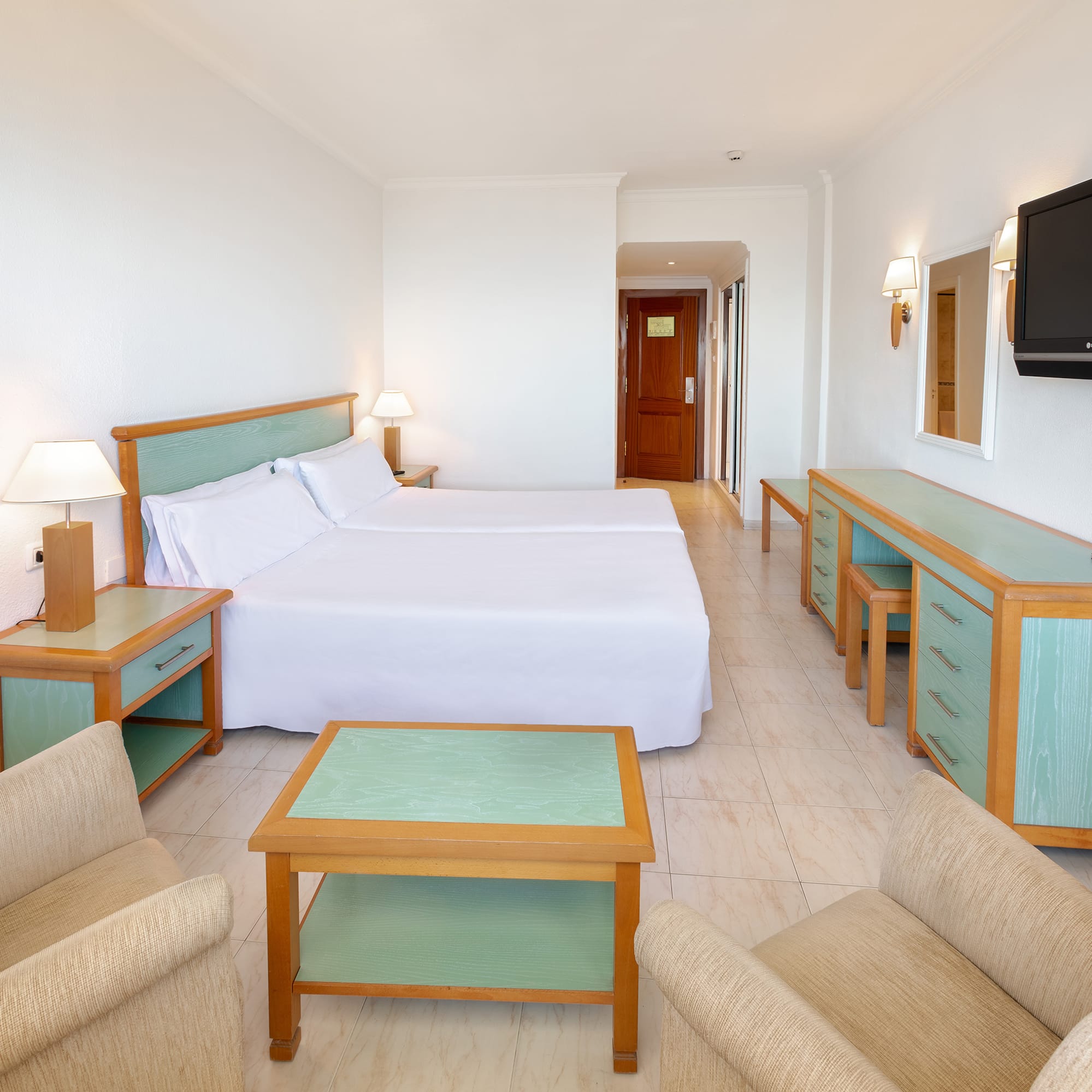 a room with two beds and a television