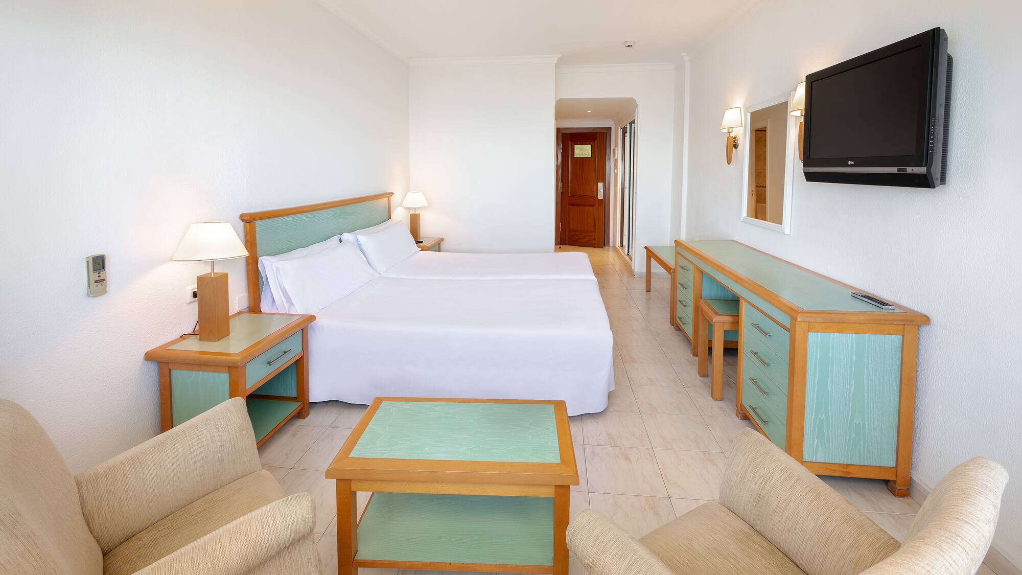 a room with two beds and a television