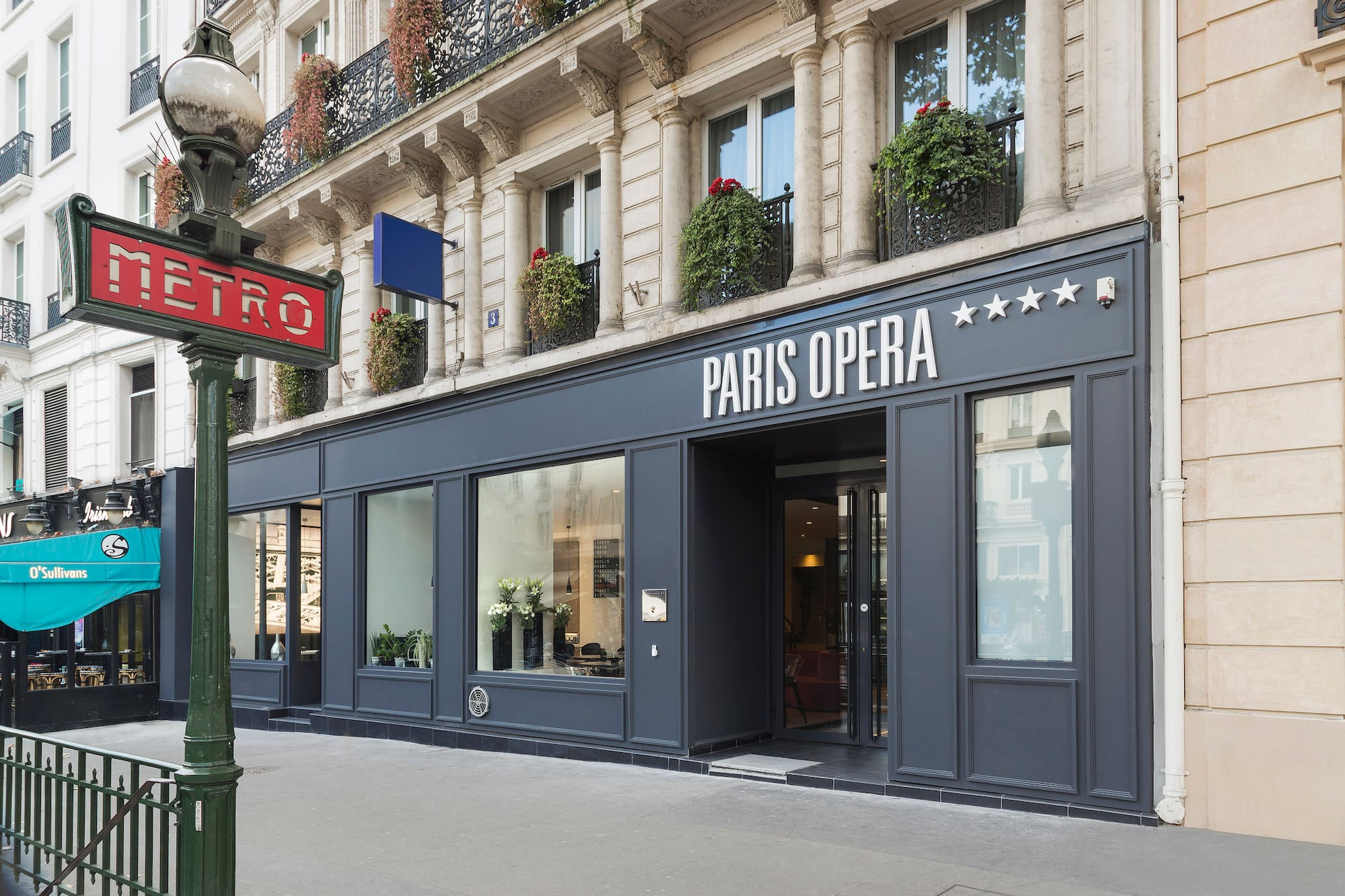 "Paris Opera" 5-star hotel facade next to a classic Parisian Metro sign.