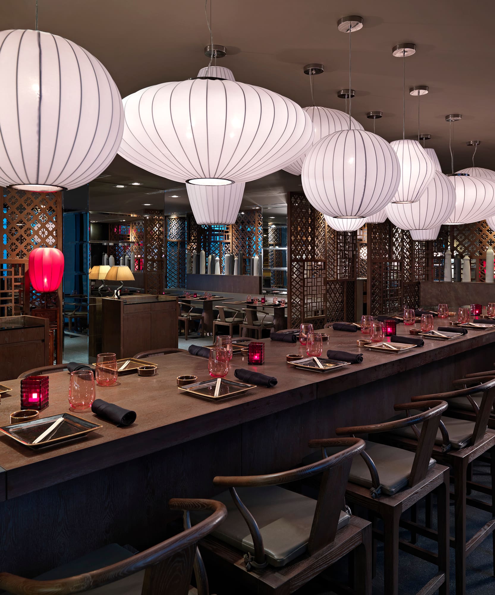 a long table with white lanterns from the ceiling