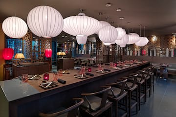 a long table with white lanterns from the ceiling