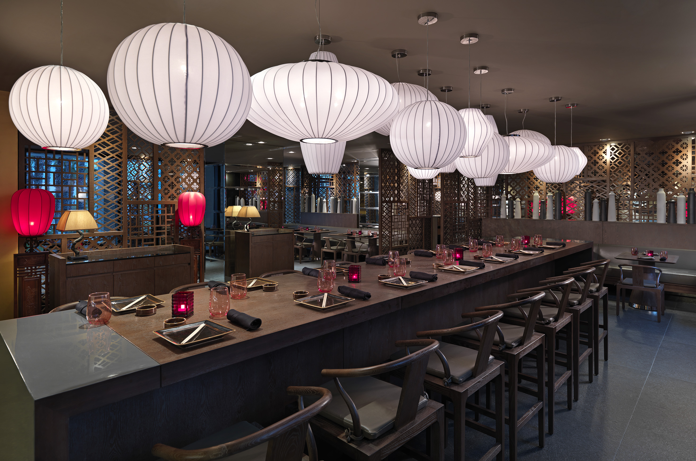 Asian restaurant bar with large white lanterns and decorative wood screens.