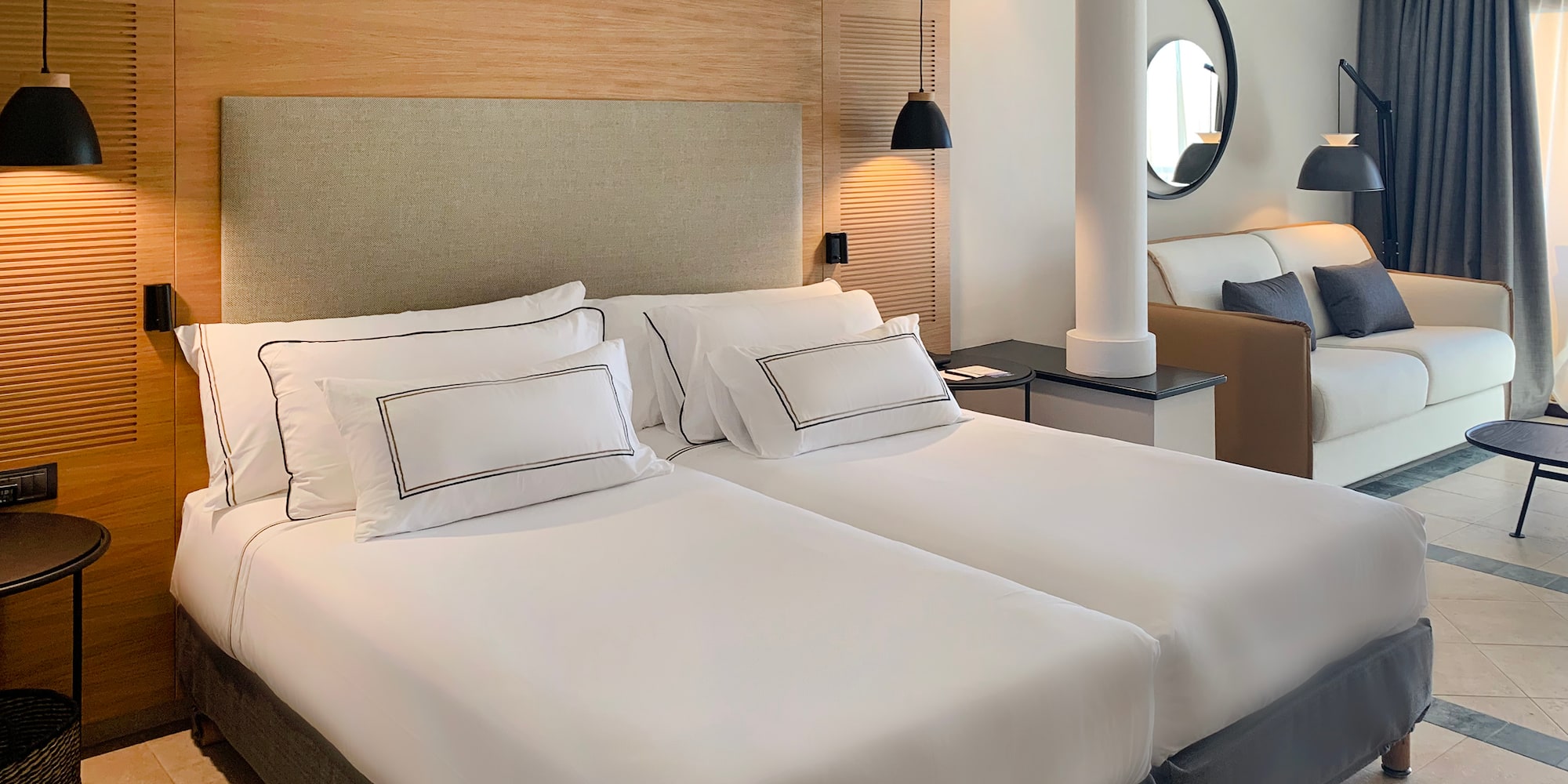 a room with two beds and a lamp