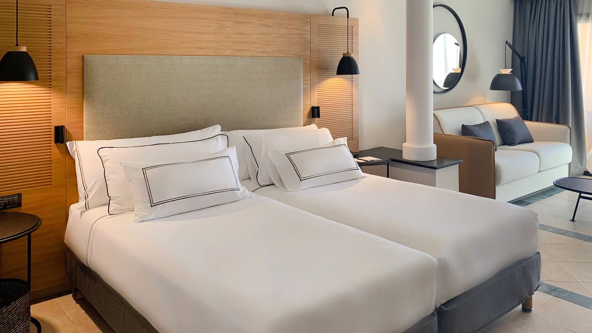 a room with two beds and a lamp