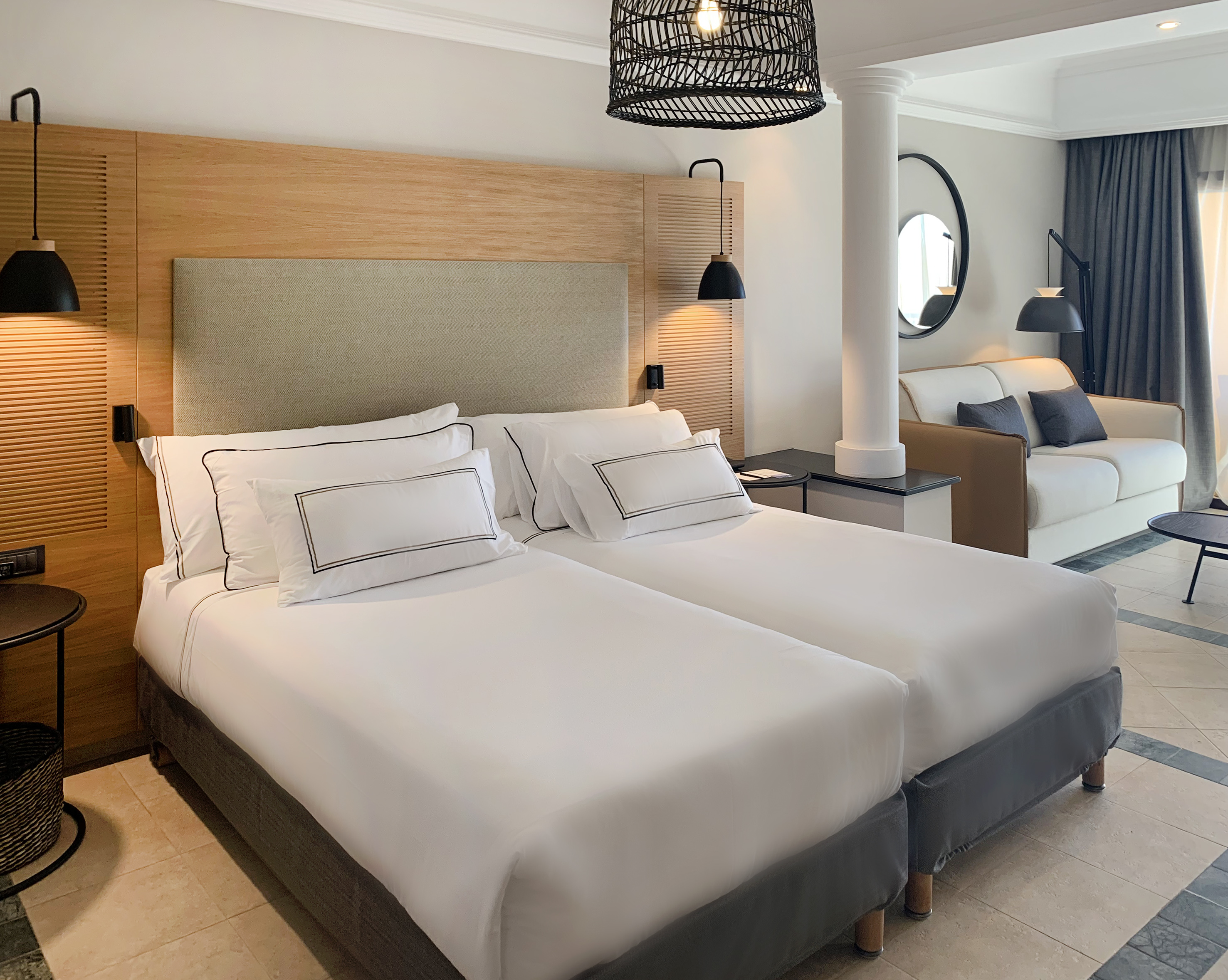 a room with two beds and a lamp