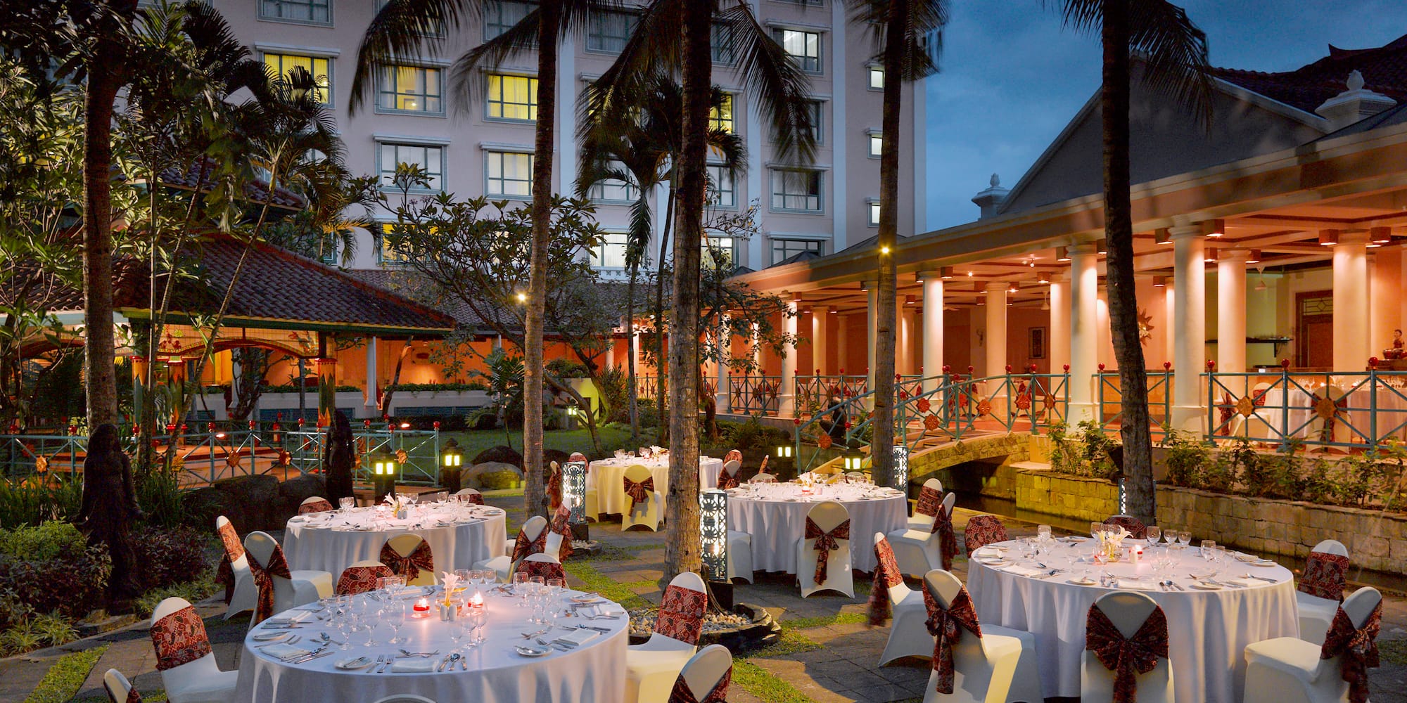 a group of tables set up outside with palm trees
