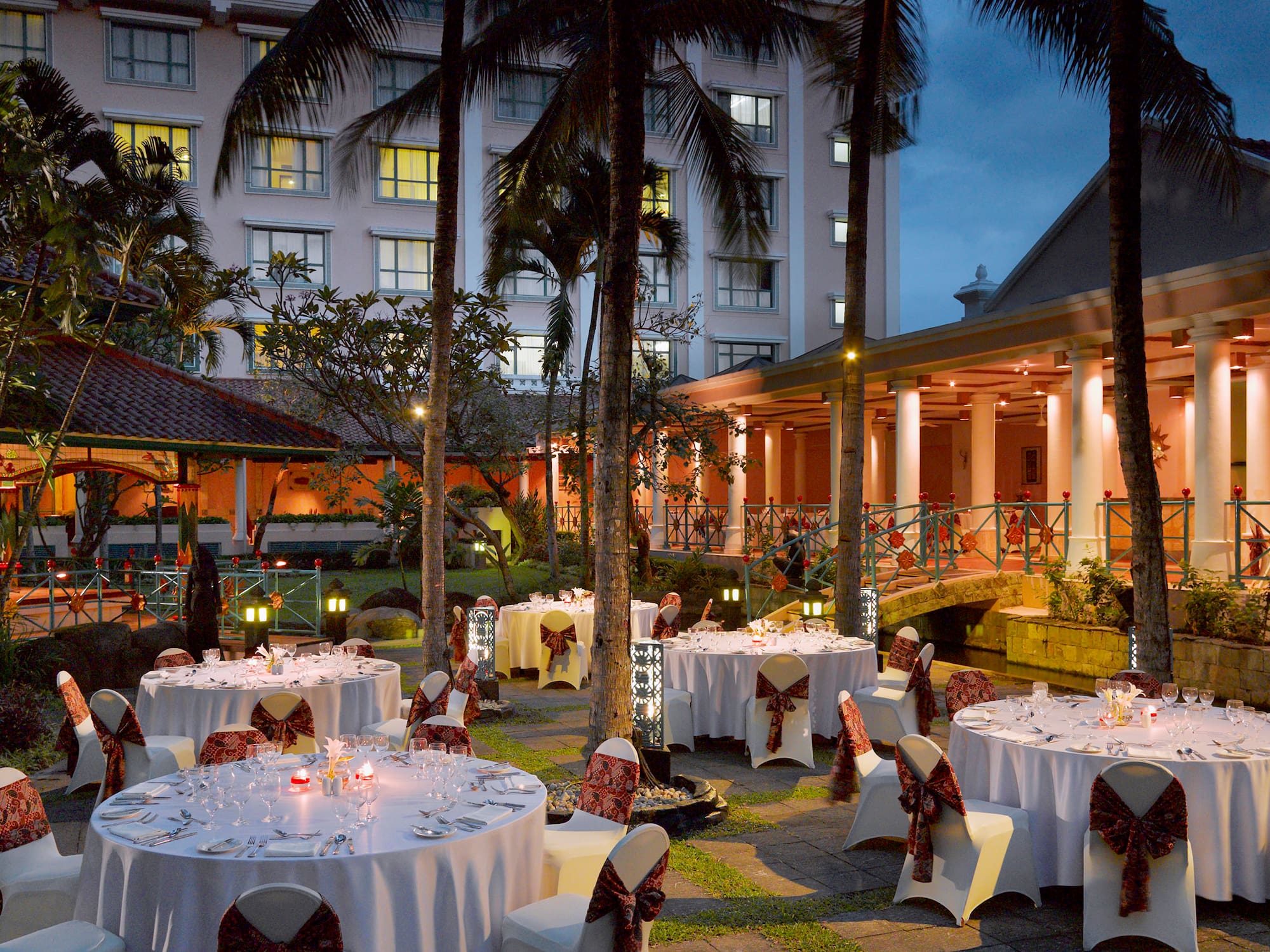 a group of tables set up outside with palm trees