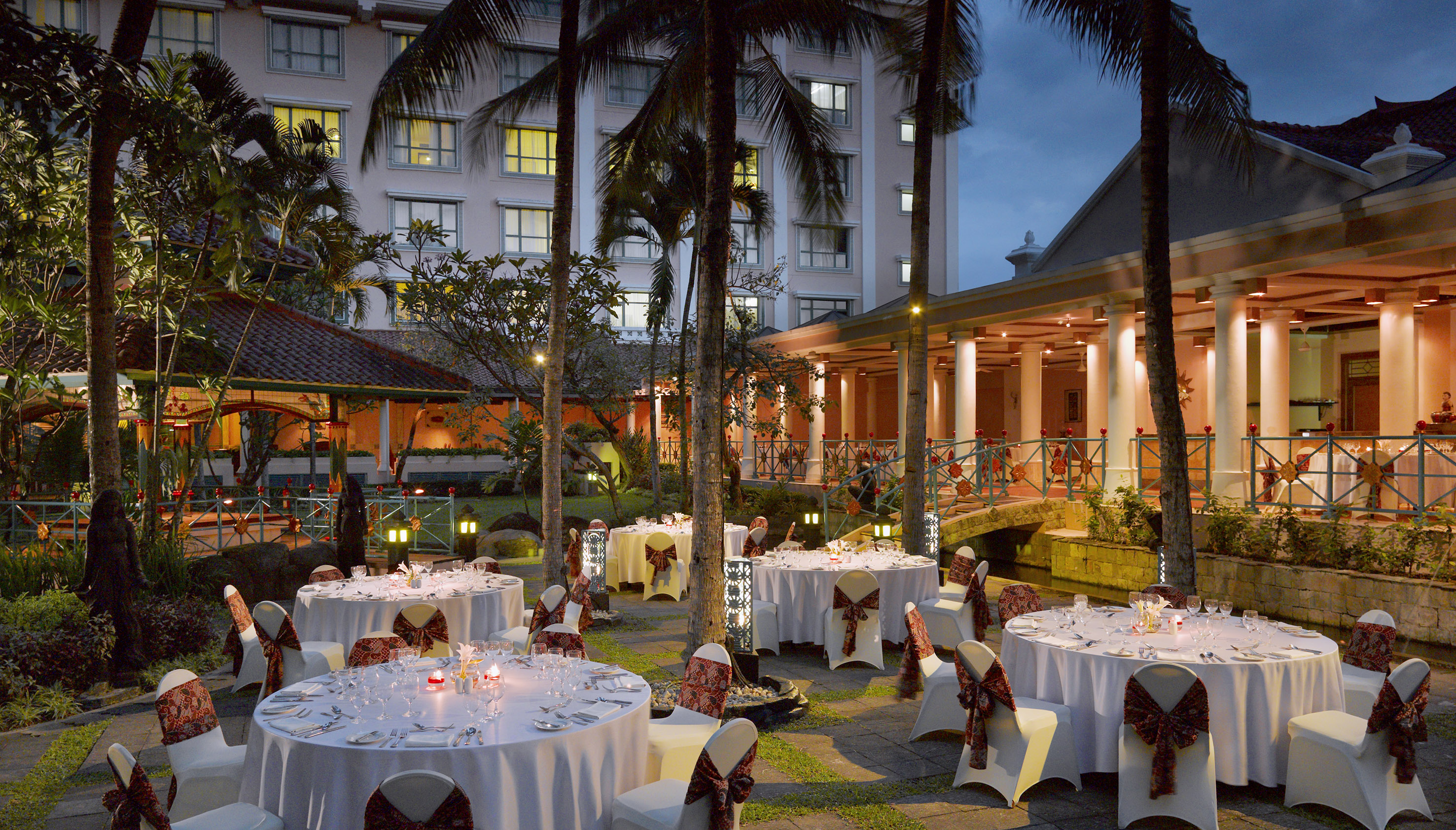 a group of tables set up outside with palm trees