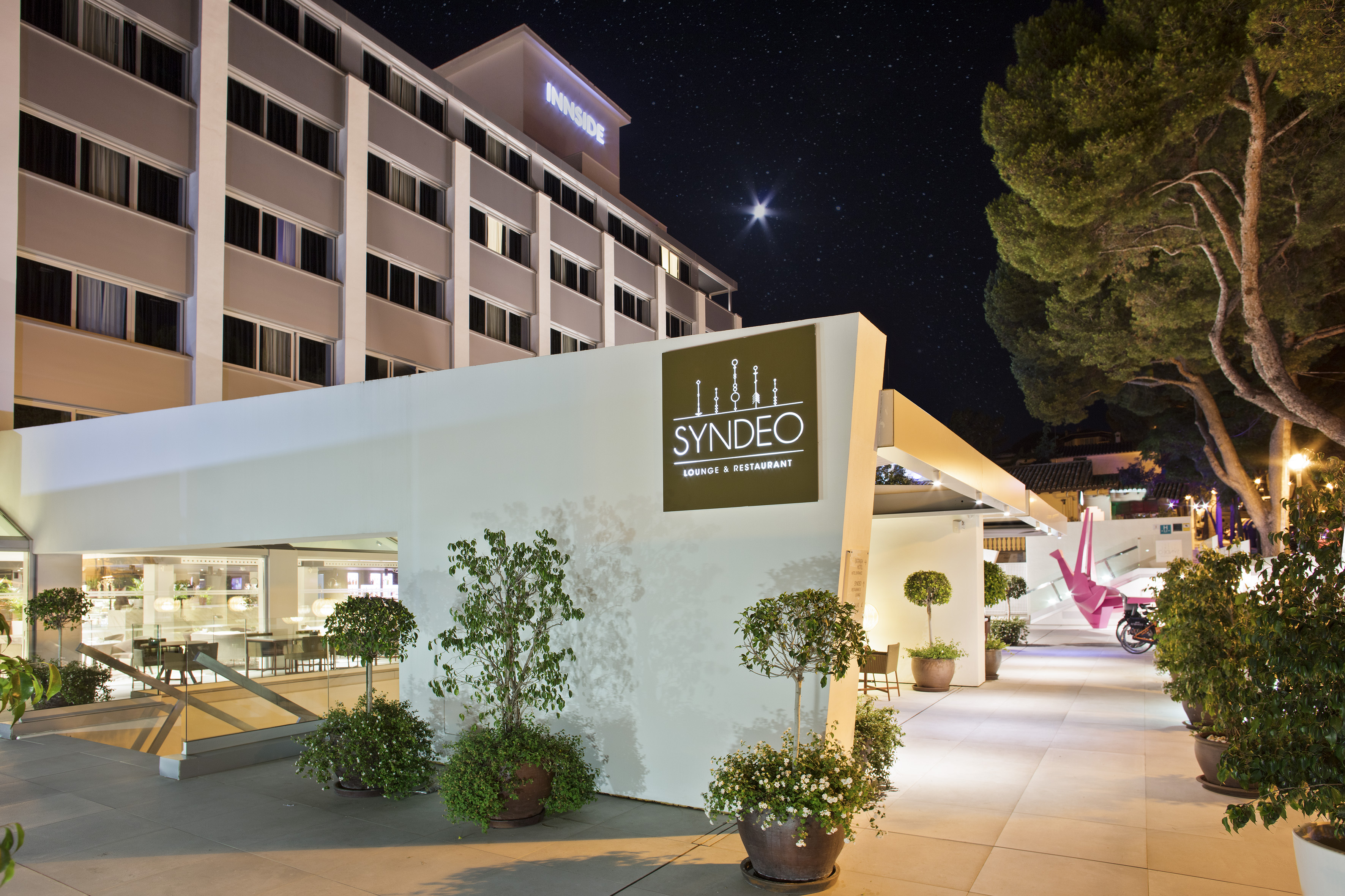 Innside hotel exterior and Syndeo Lounge & Restaurant entrance at night.