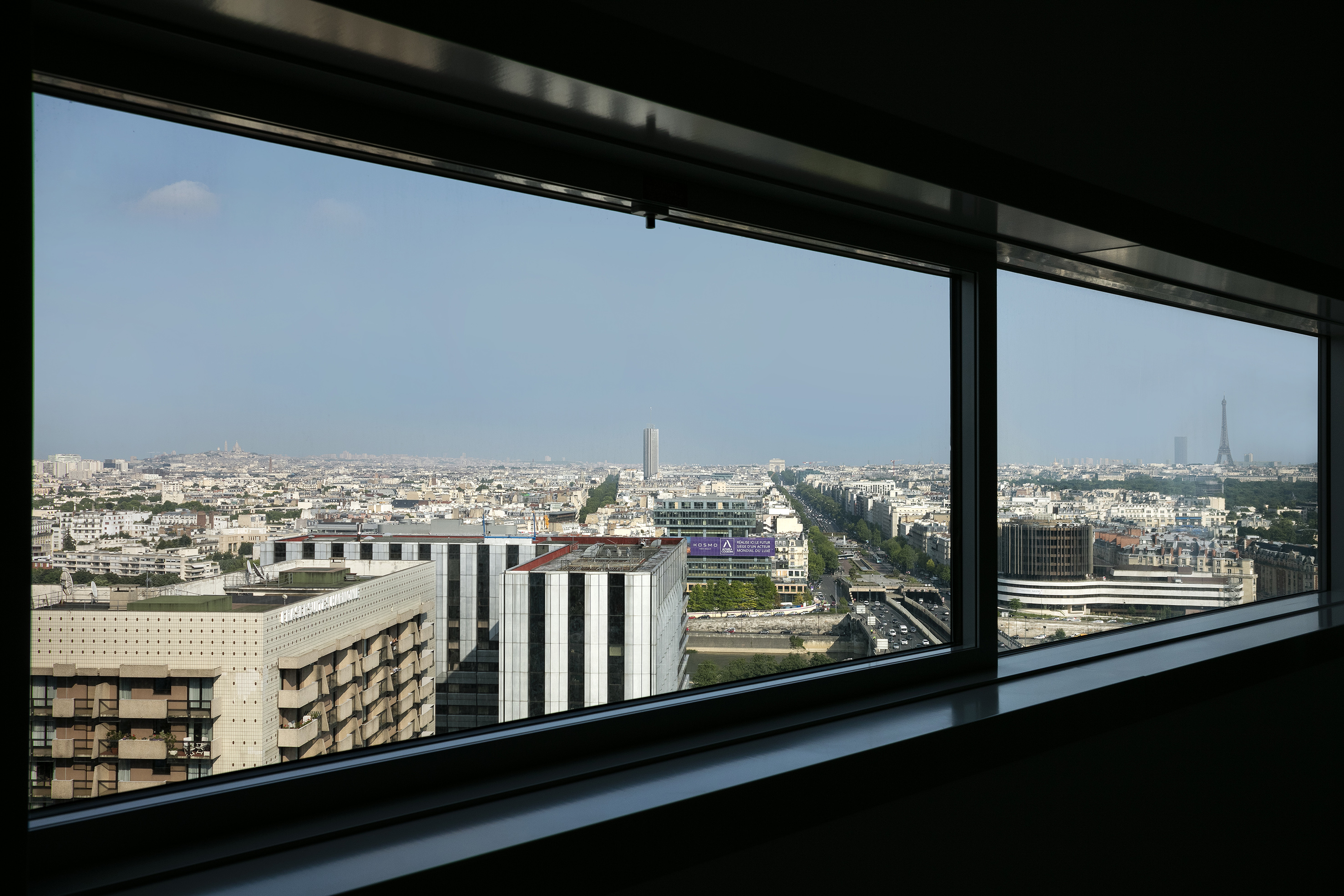 Paris skyline from window, featuring Eiffel Tower, Montparnasse Tower.