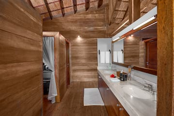 a bathroom with a wood wall and a wooden ceiling