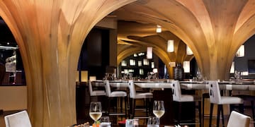 a restaurant with a table of food and glasses of wine