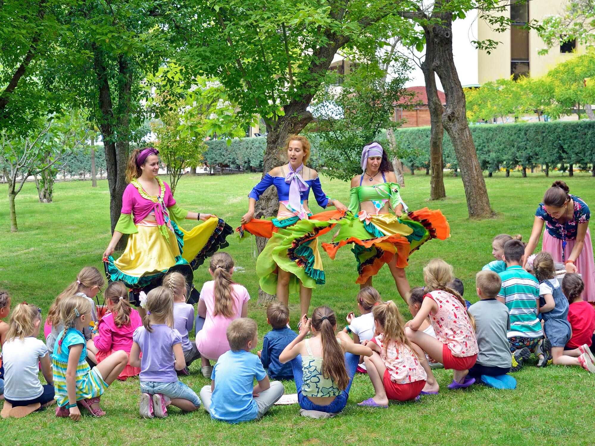 a group of people in colorful dresses performing a circle of dancing