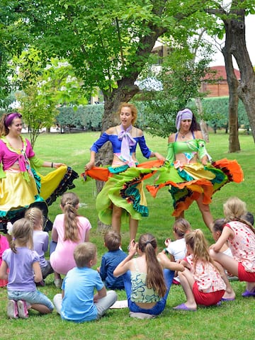 a group of people in colorful dresses performing a circle of dancing