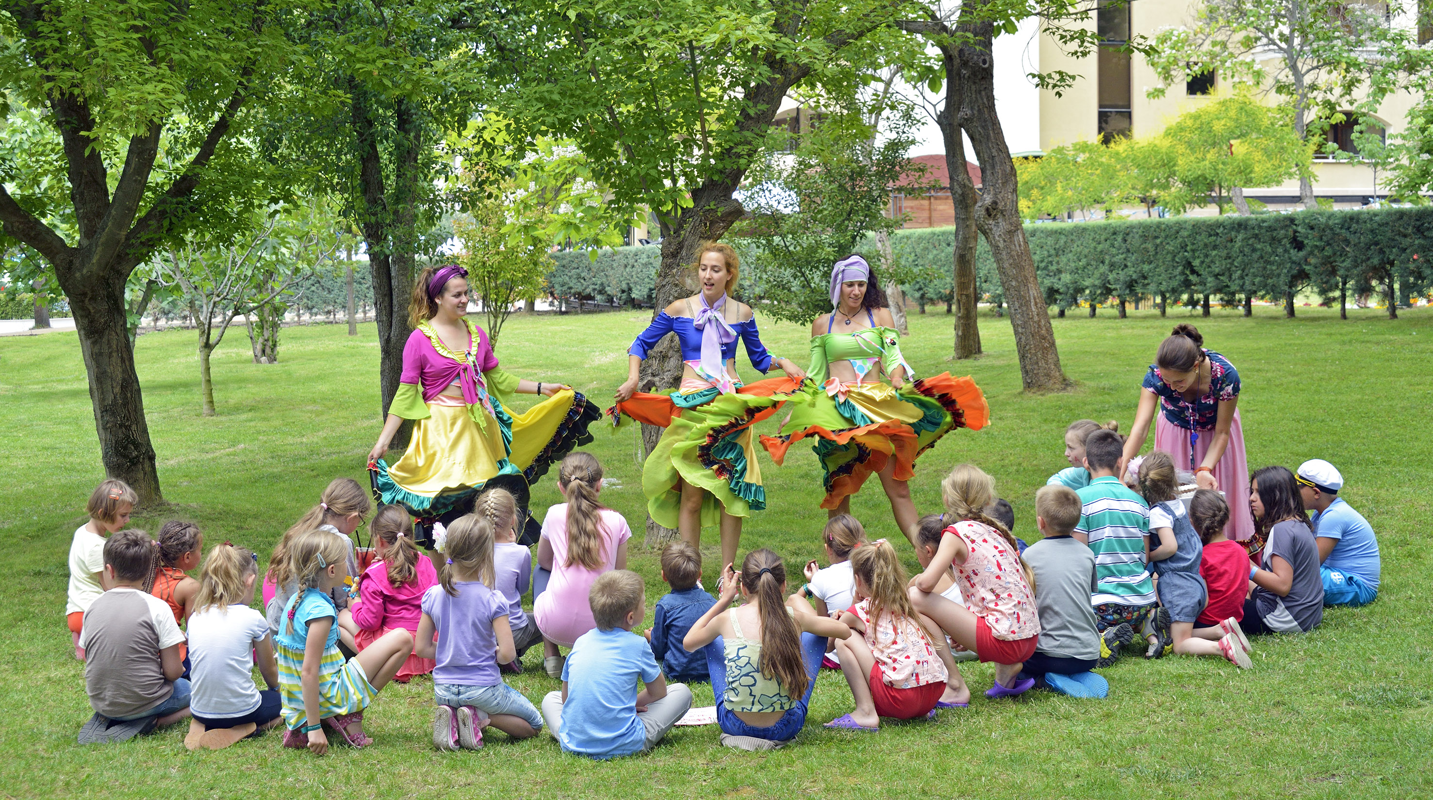 a group of people in colorful dresses performing a circle of dancing