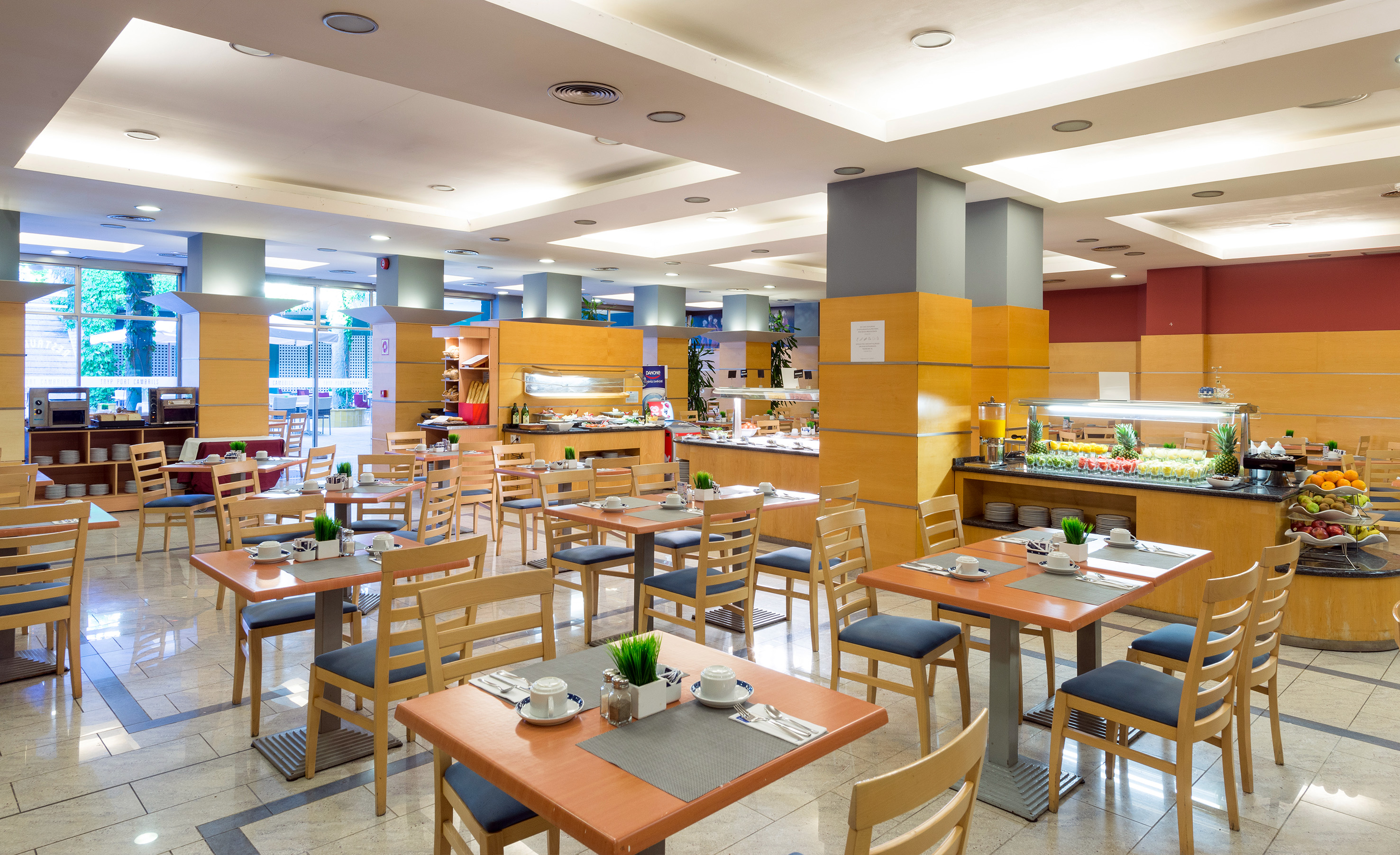 Spacious hotel buffet restaurant with set tables and fresh food options.