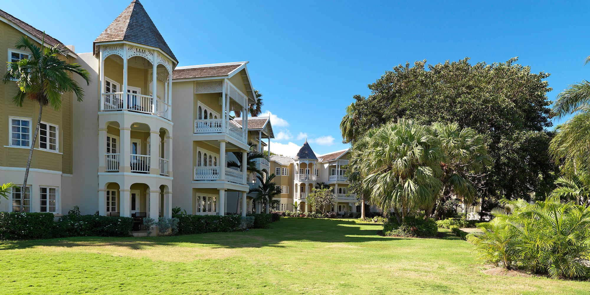 a large building with a lawn and trees