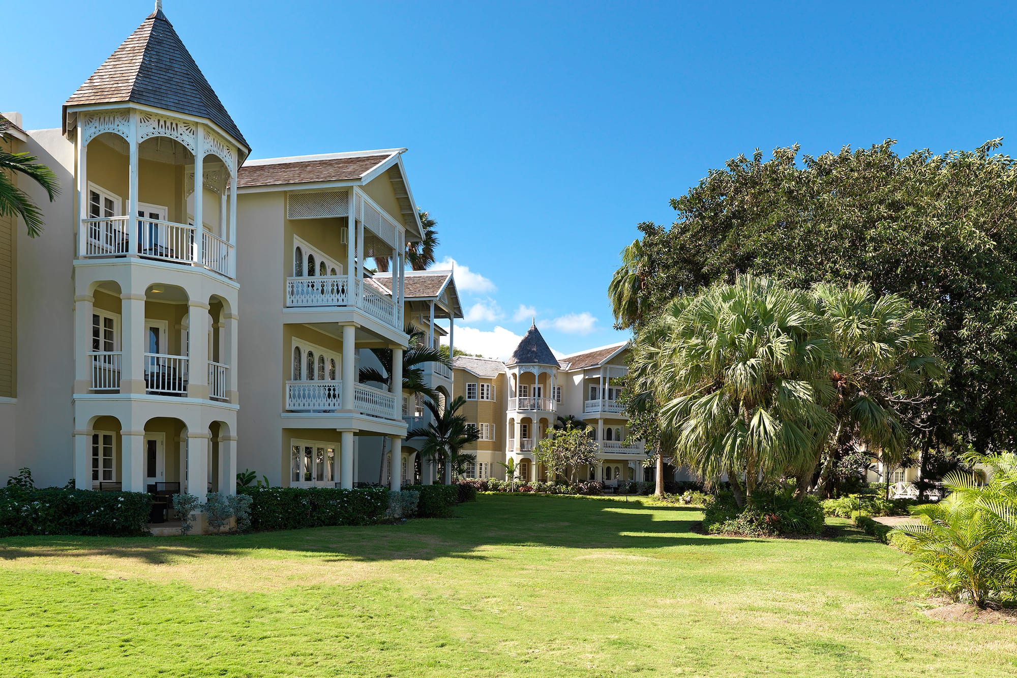 a large building with a lawn and trees