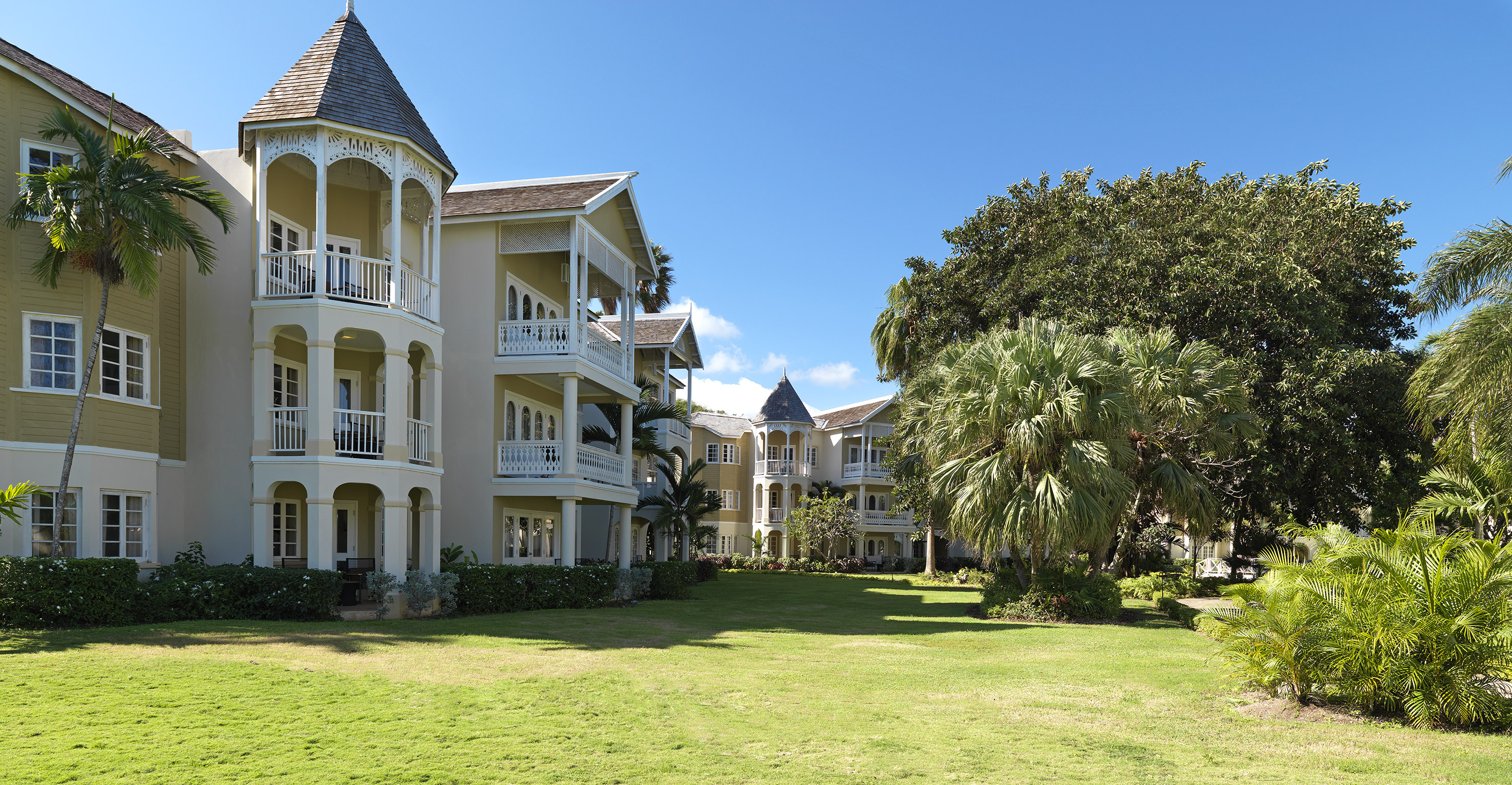 a large building with a lawn and trees