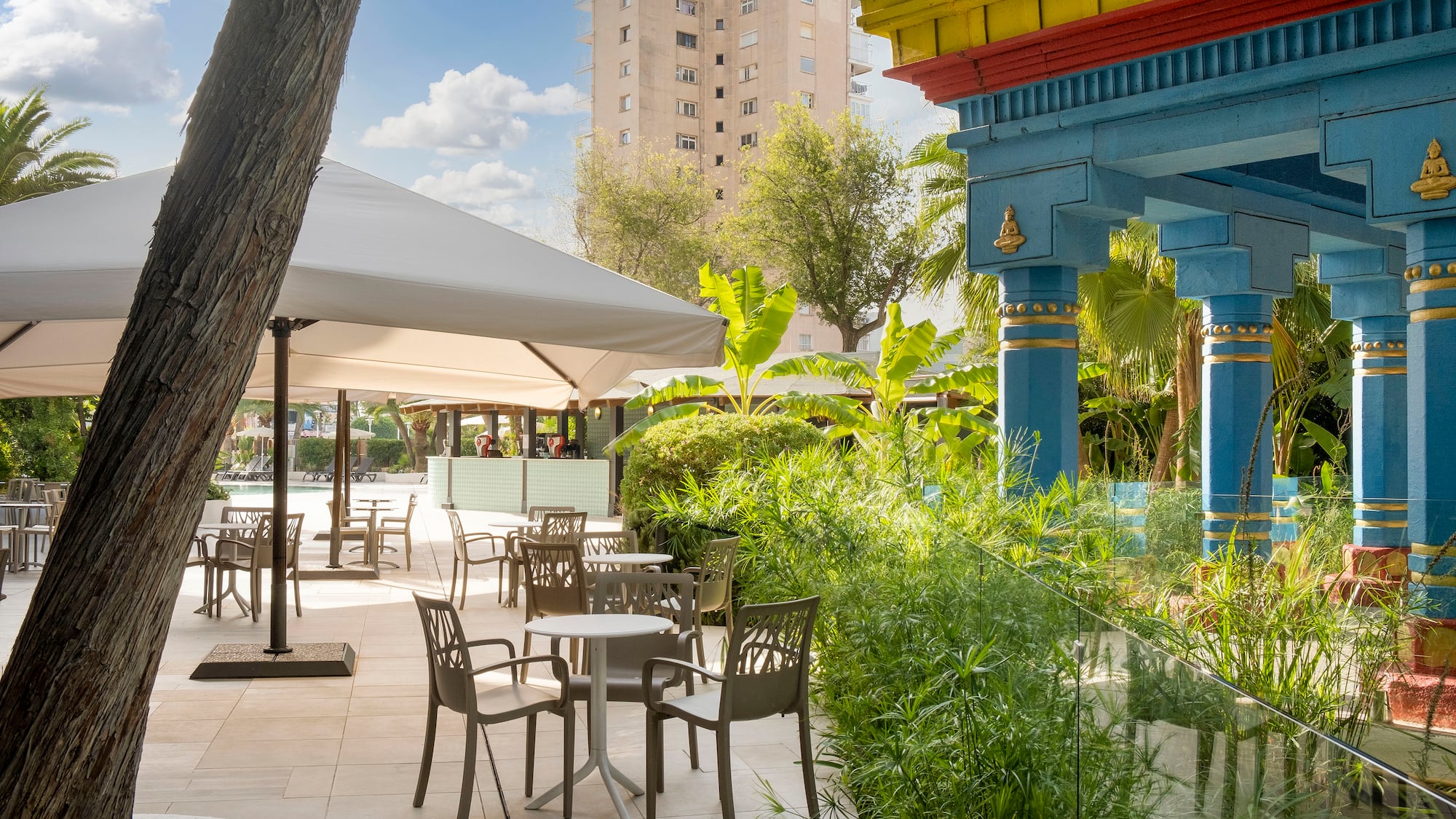 a patio area with tables and chairs and trees