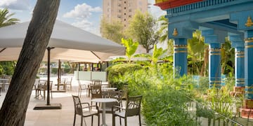 a patio area with tables and chairs and trees
