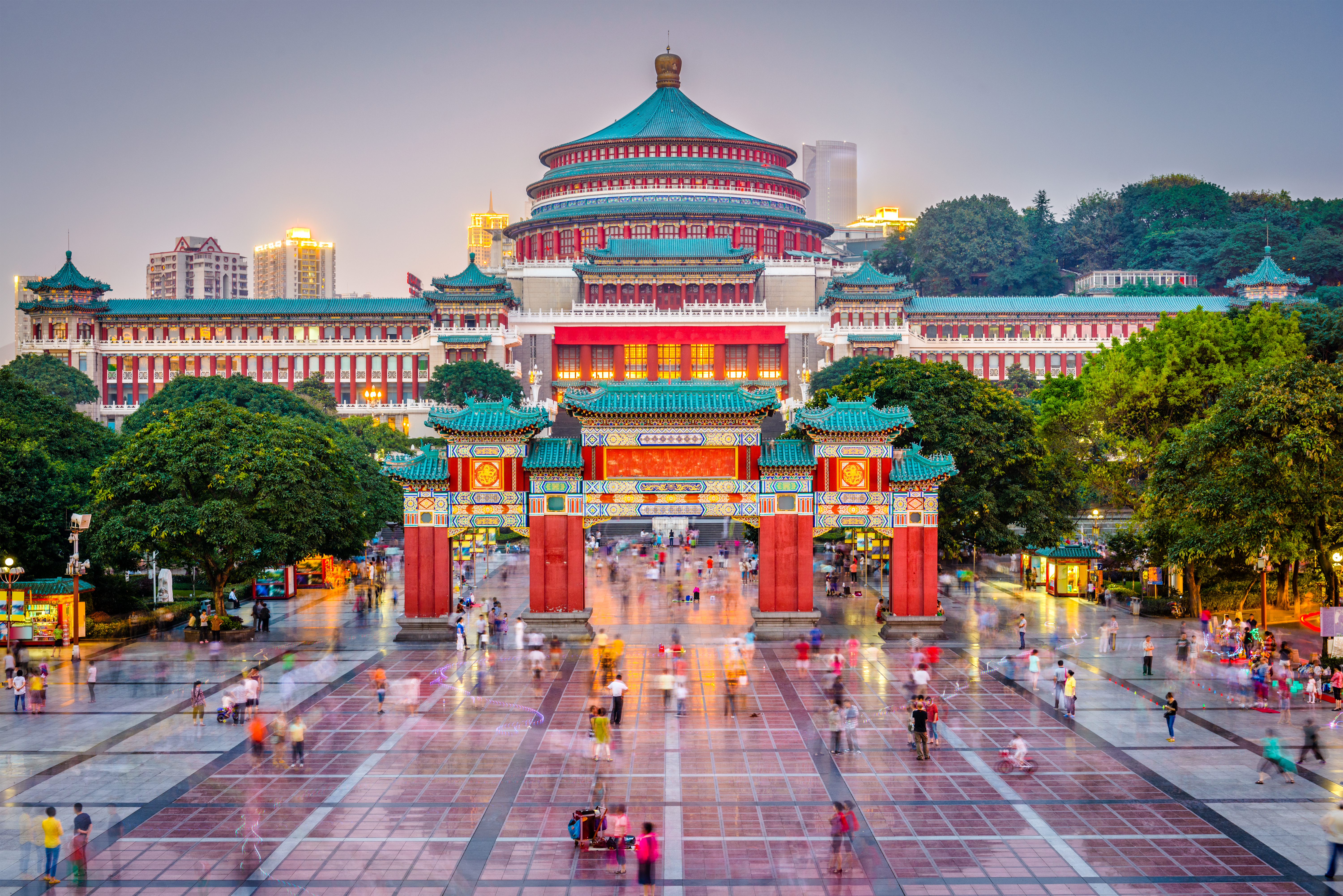 Chongqing Great Hall of the People at dusk, bustling plaza, traditional Chinese architecture.