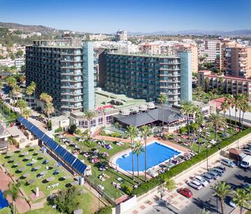a large building with a pool and trees