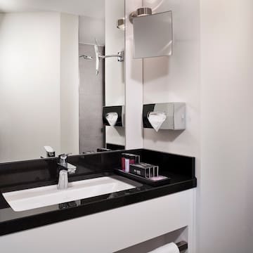 a bathroom with a black countertop and a mirror