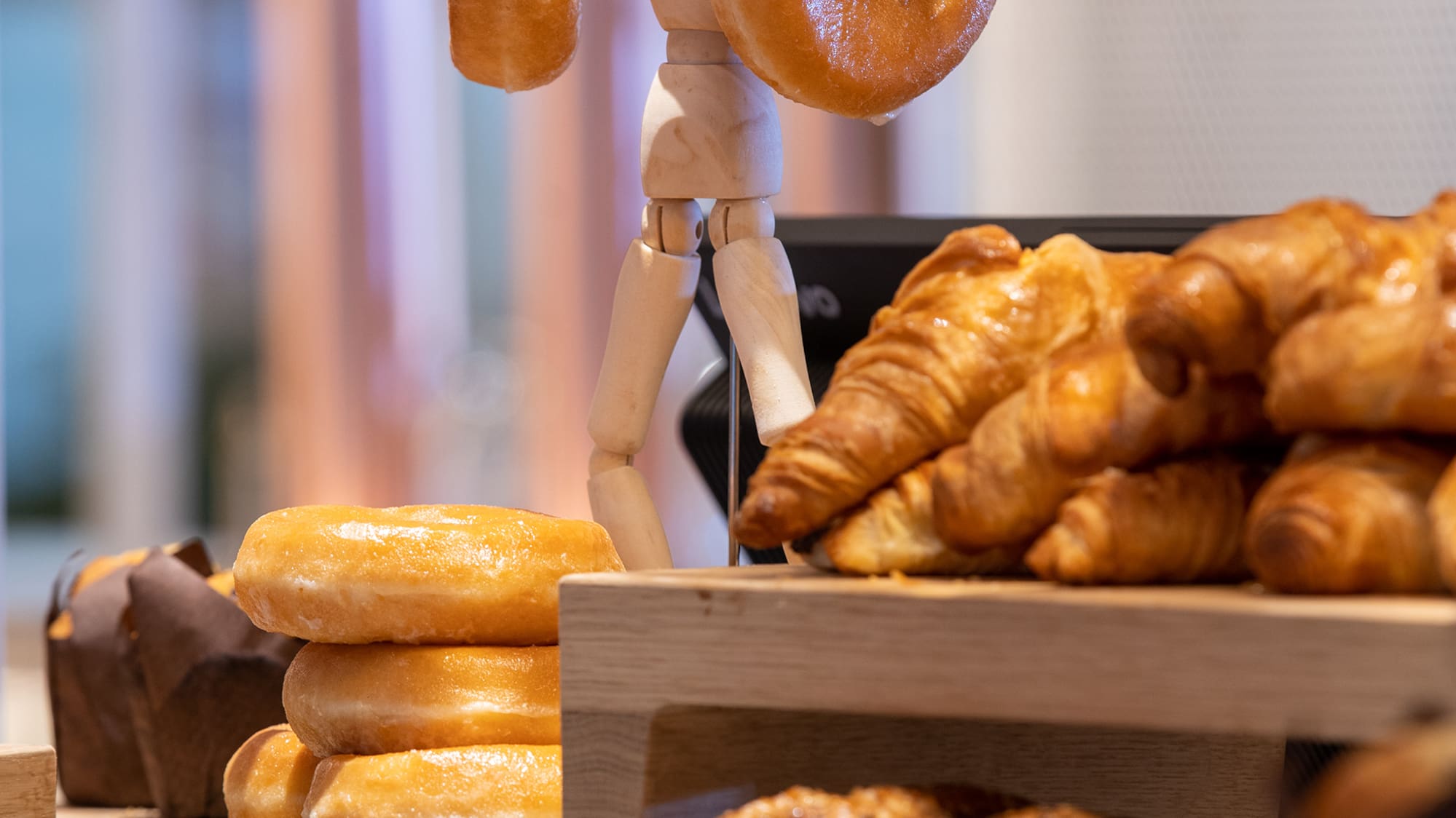 a wooden figure holding a doughnut