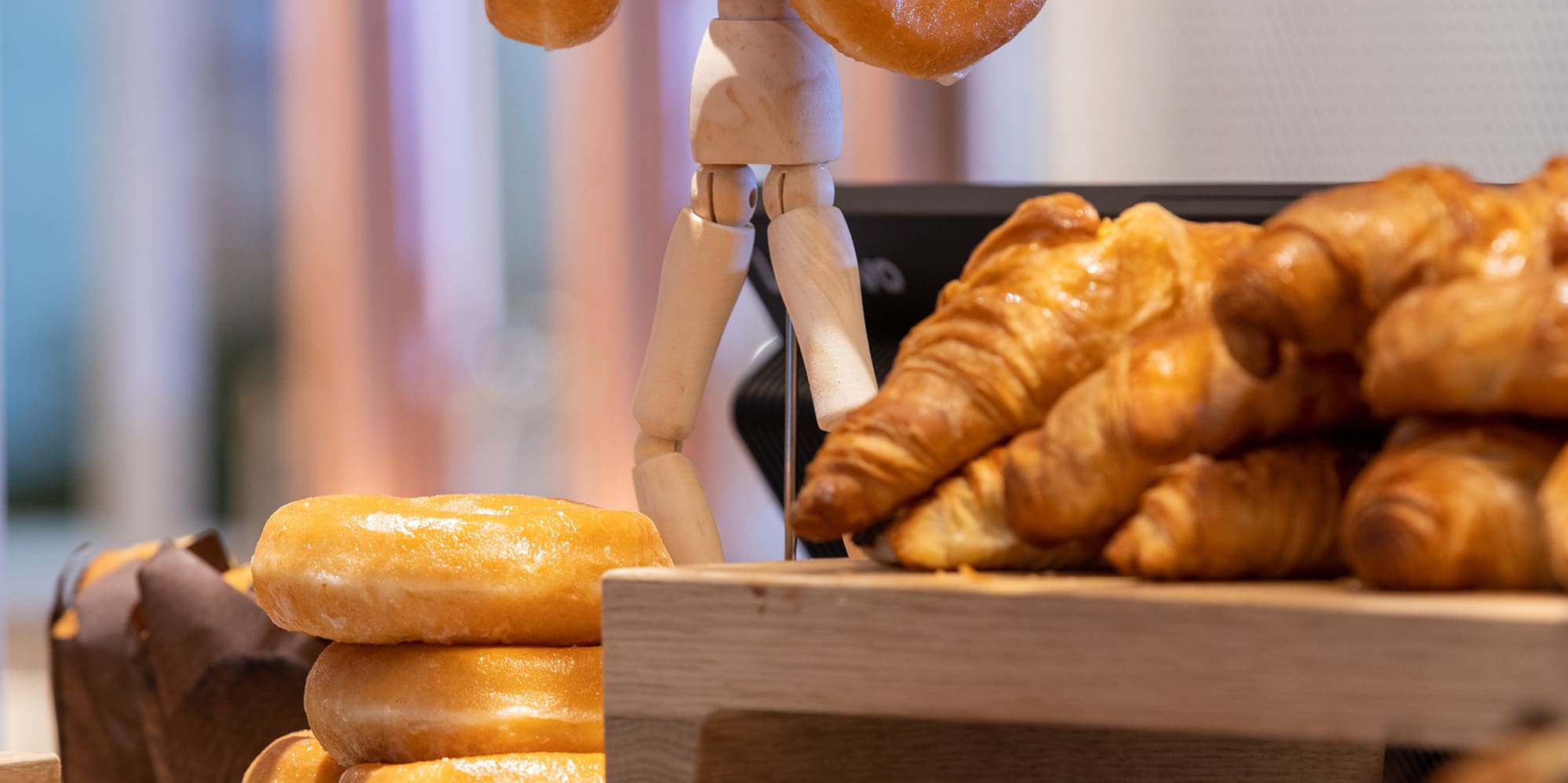 a wooden figure holding a doughnut