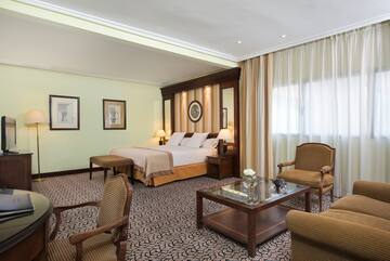a room with a bed and chairs