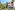 White Mediterranean hotel, arched balconies, palm trees, sunny garden.