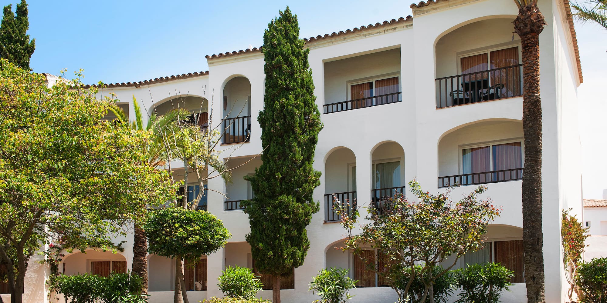a white building with trees and bushes