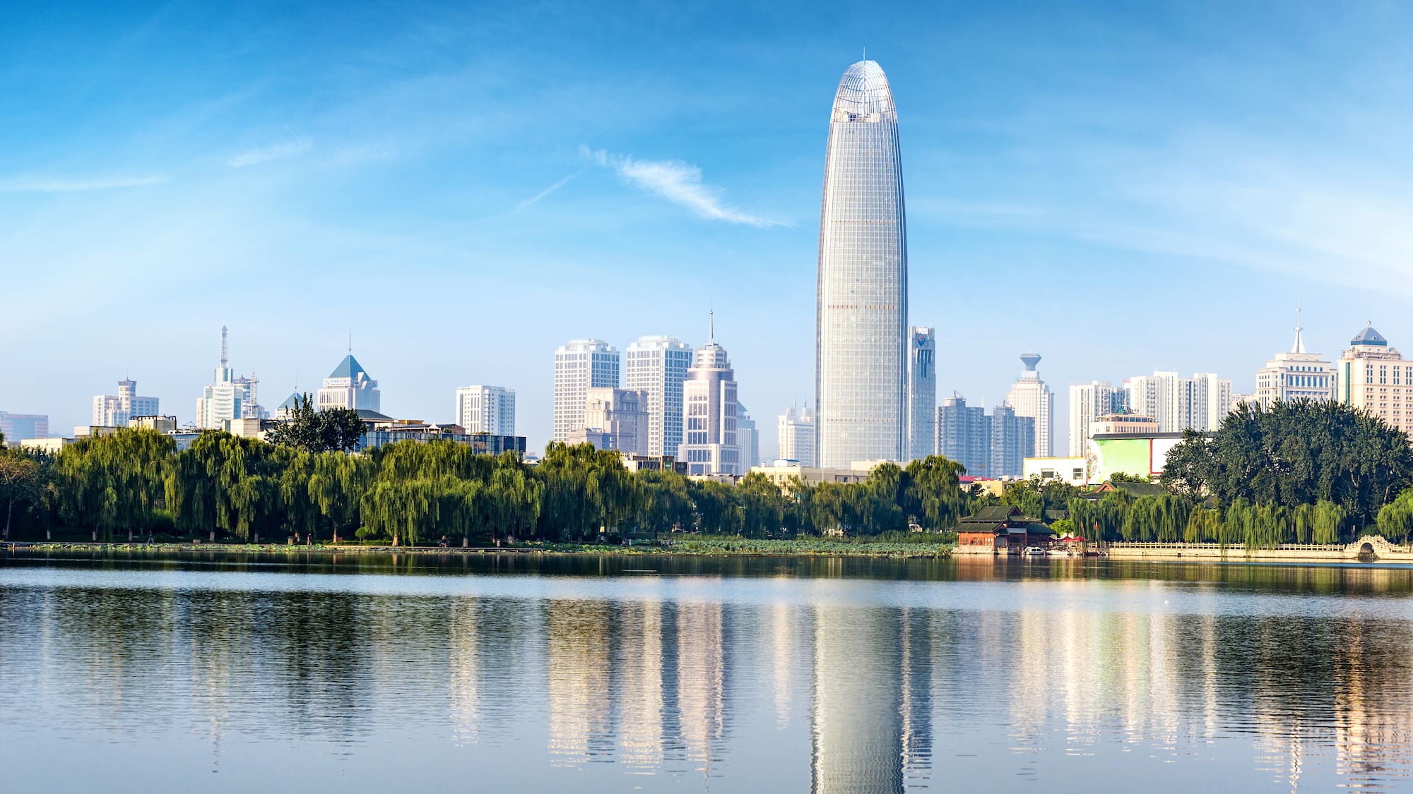 a city skyline with trees and water