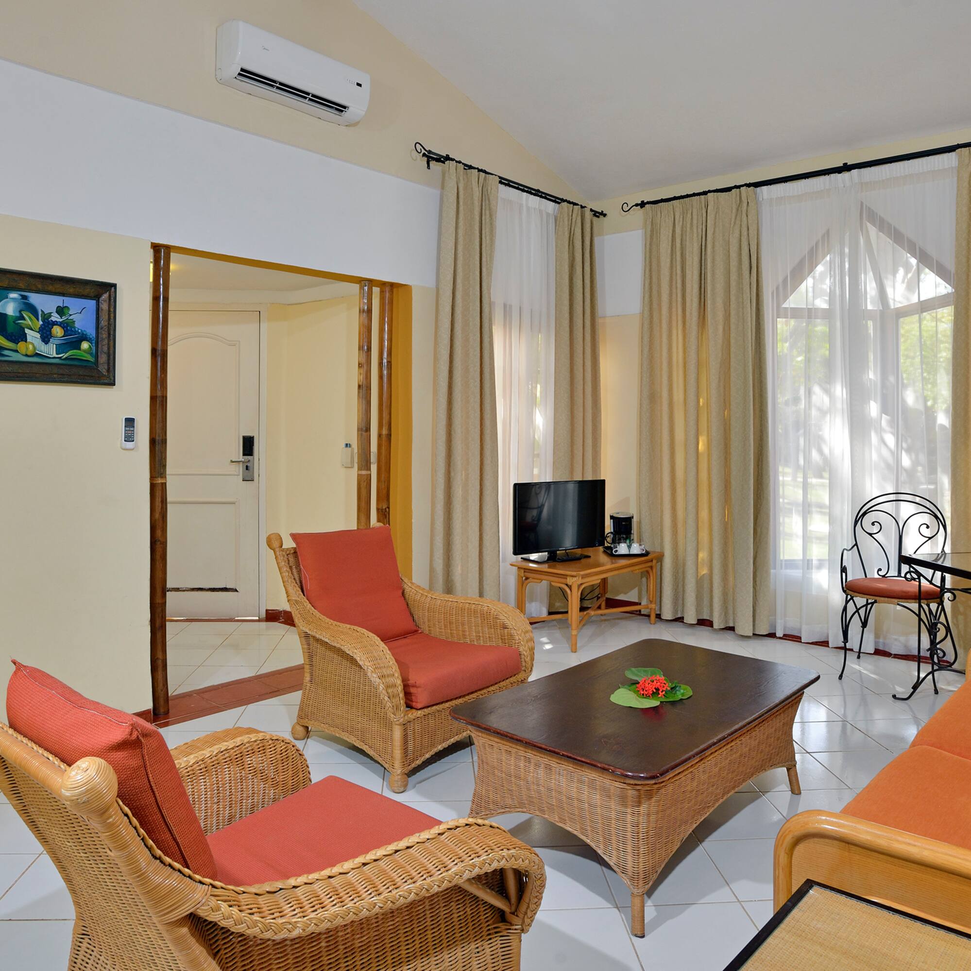 a living room with wicker furniture and a table