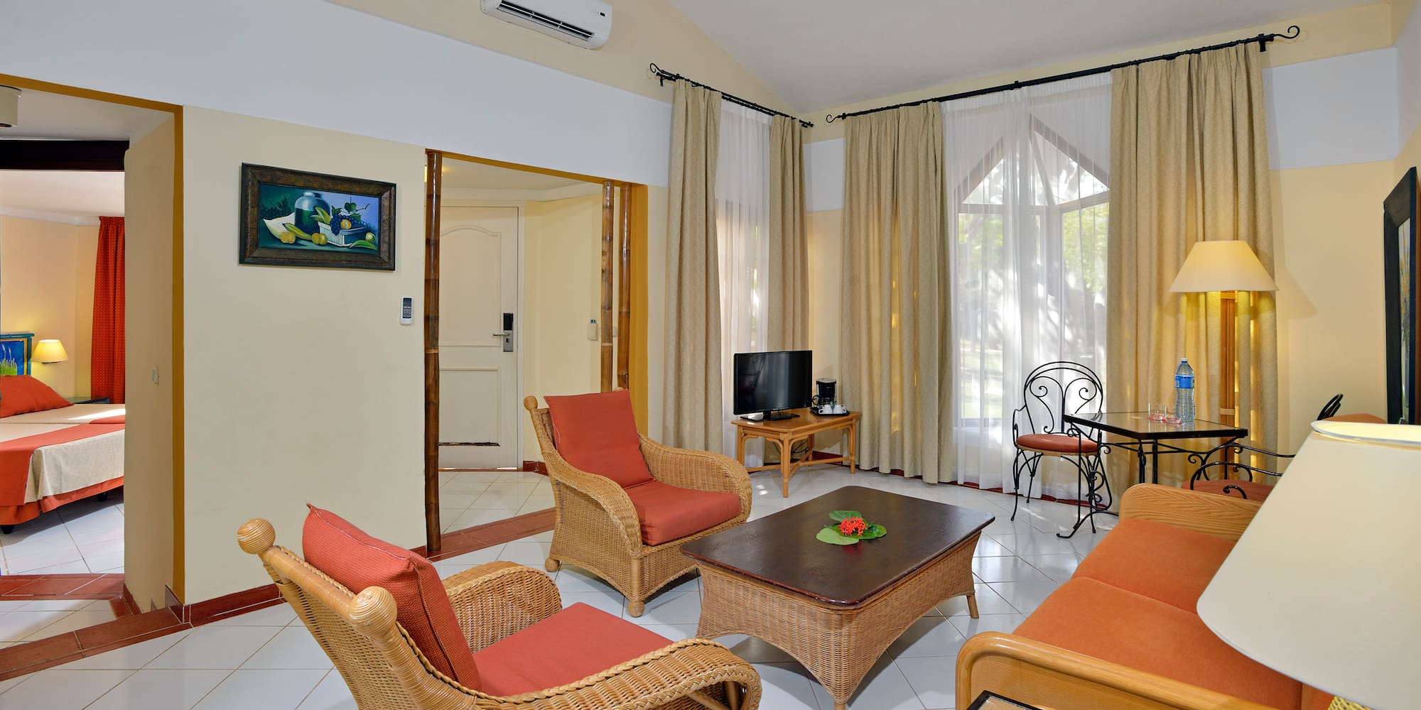 a living room with wicker furniture and a table