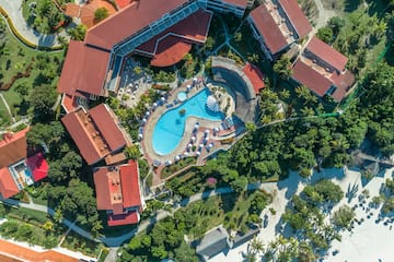 an aerial view of a resort with a pool and buildings