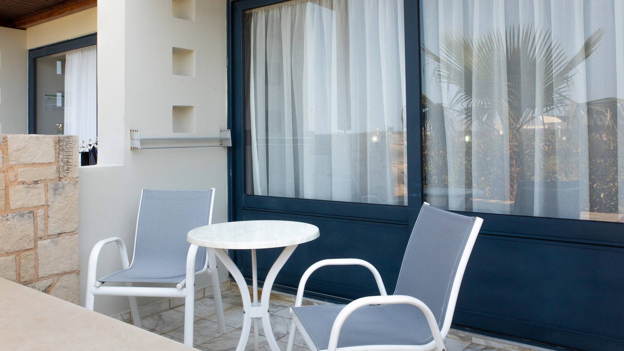 a table and chairs outside a blue door